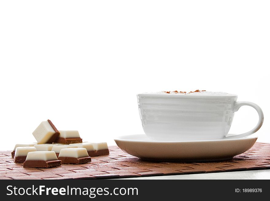 White cup of coffee with chocolate on brown base