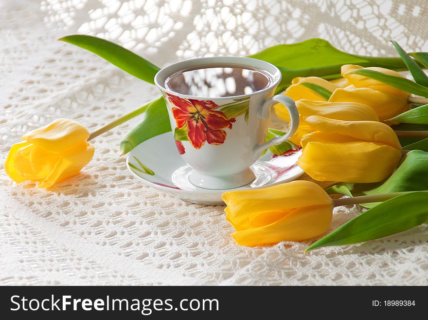 White cup of tea with red and yelow flowers. White cup of tea with red and yelow flowers