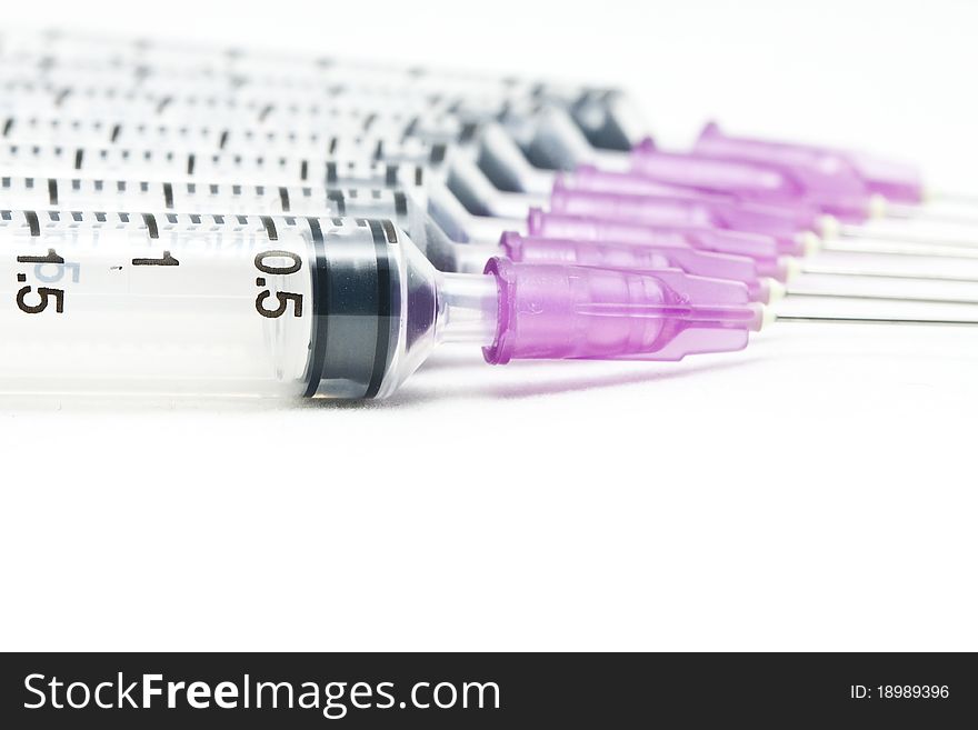 Closeup, Isolated disposable syringes in the row on white background