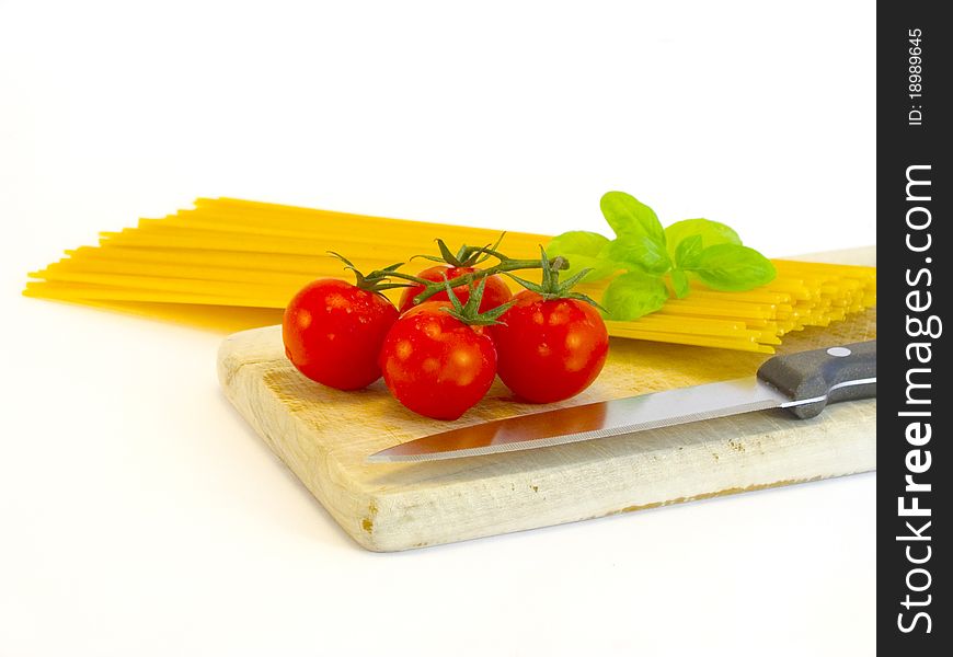 Tasty spaghetti with tomatoes and basil on a carving board. Tasty spaghetti with tomatoes and basil on a carving board