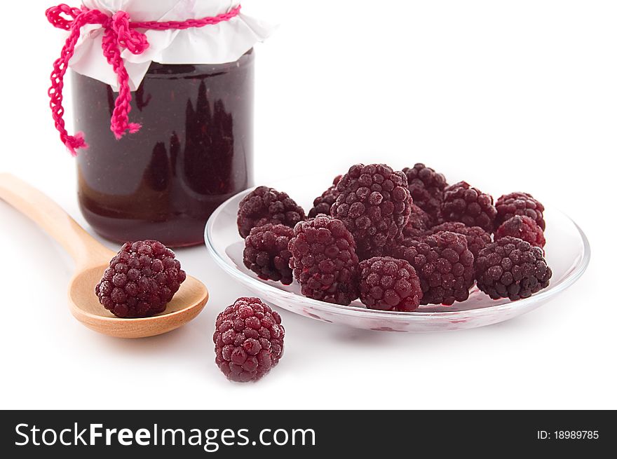 Blackberry jam in bowl and berries on plate and spoon