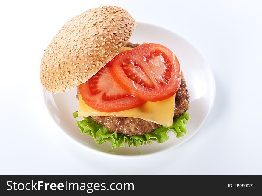 Cheeseburger with tomatoes and lettuce isolated on white