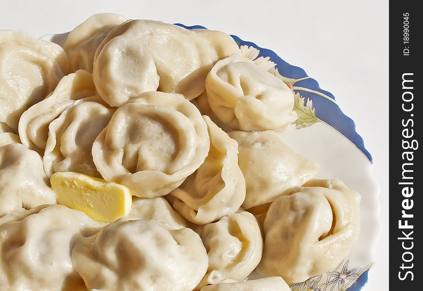 Ravioli with butter in a dish on a white background