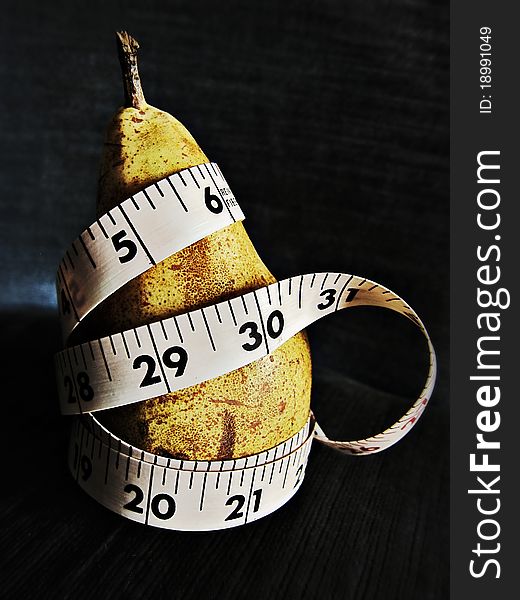 Diet concept: tape around a pear. Diet concept: tape around a pear