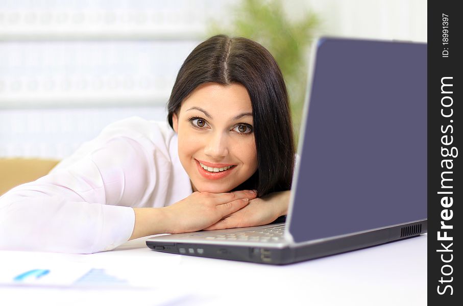 The beautiful business woman with the computer at office