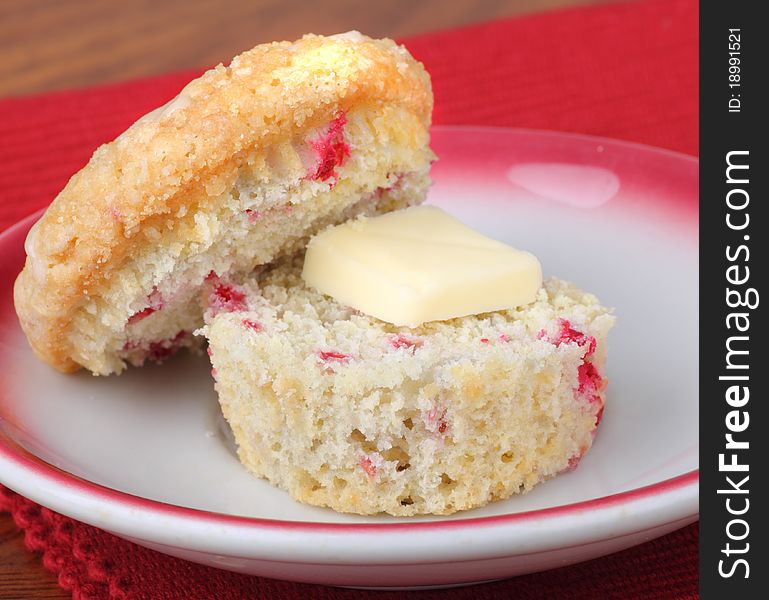 Sliced raspberry muffin with butter on a plate