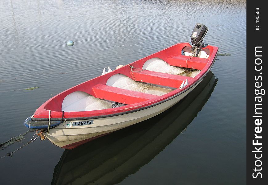 A rowboat in the sea, with an engine. A rowboat in the sea, with an engine.