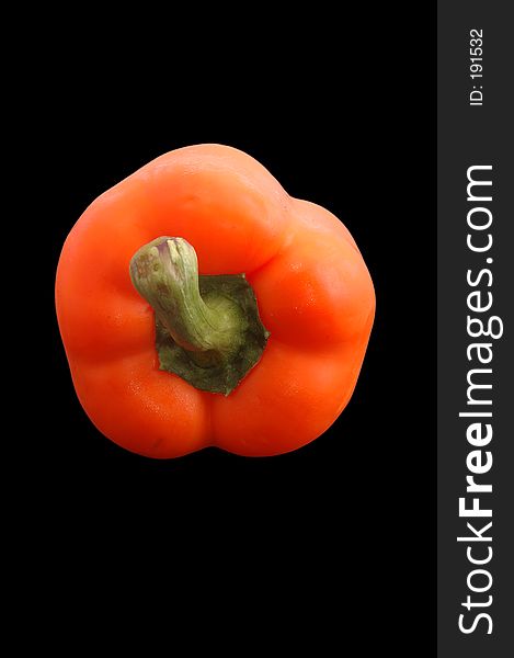 A fresh orange bell pepper over black