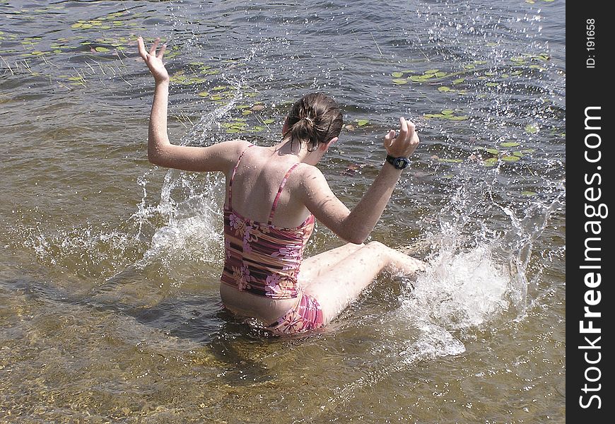 Young girl at the beach having fun to splash water all around. Young girl at the beach having fun to splash water all around