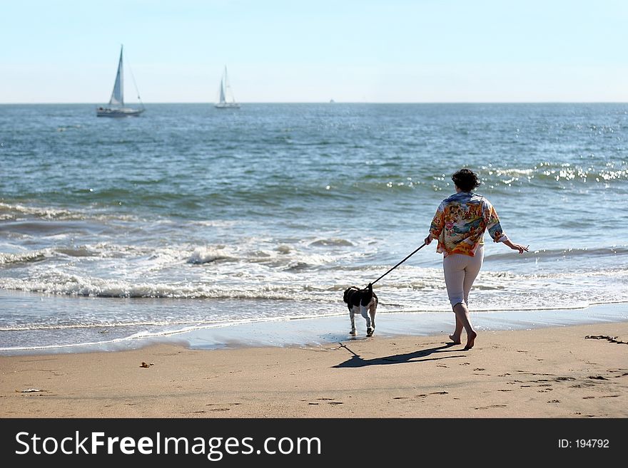Woman with a dog on the beach