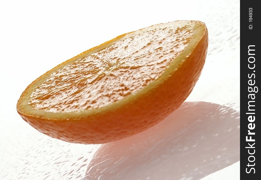 Half an Orange. Sunlit. With Water Drops.