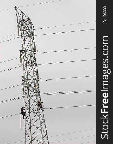 Workers climbing on power pylon