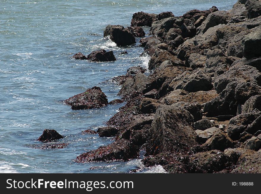 This is a shot of the beach front with the rocks and tide. This is a shot of the beach front with the rocks and tide.