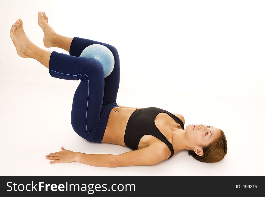 A female fitness instructor demonstrates an abductor squeeze - start. A female fitness instructor demonstrates an abductor squeeze - start