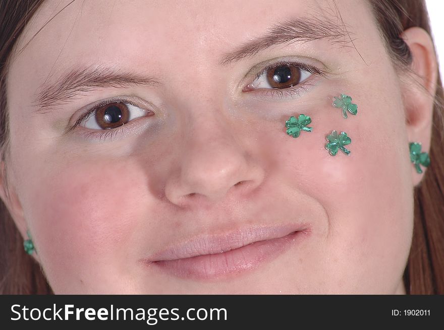 A smiling woman with green shamrocks on her cheek. A smiling woman with green shamrocks on her cheek.
