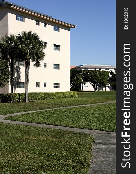 A typical condo complex found in southern florida with palm trees and nice walking path. A typical condo complex found in southern florida with palm trees and nice walking path
