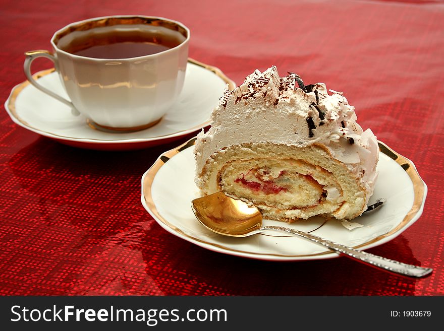 Cup Of Tea With The Spoon And A Slice Of Pie On Red Background