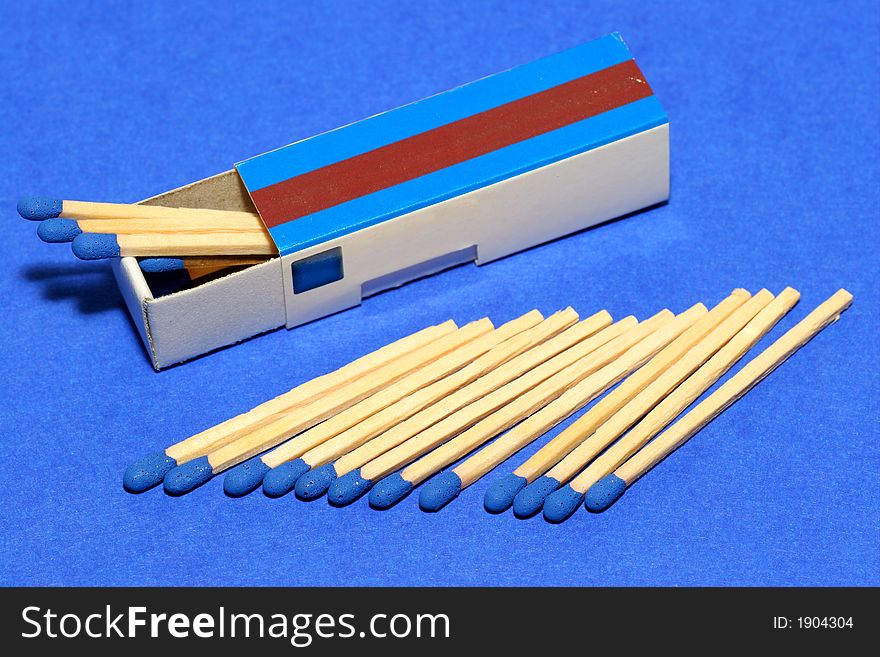 Blue matches with fitting box on blue background. Studio picture. Blue matches with fitting box on blue background. Studio picture