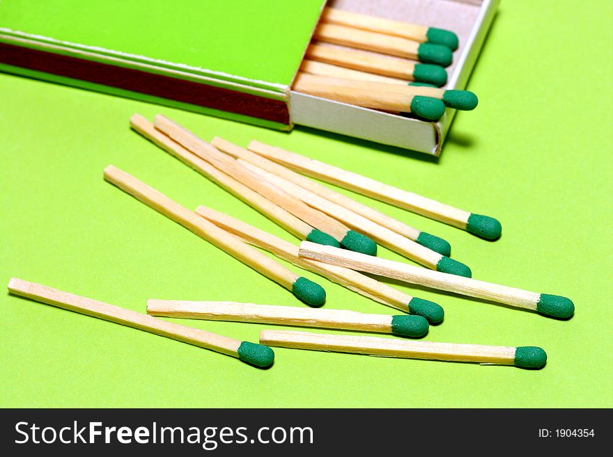 Green matches with fitting box on green background. Studio picture. Green matches with fitting box on green background. Studio picture