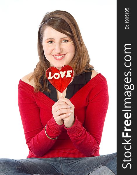 Girl holding a big red 'love' lollipop. Isolated on white. Girl holding a big red 'love' lollipop. Isolated on white.