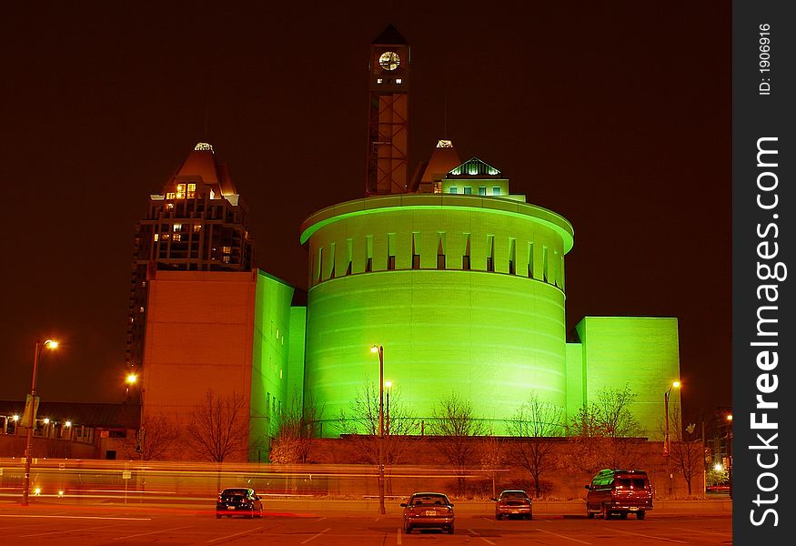 Photo of bus passing by on green iliuminated building