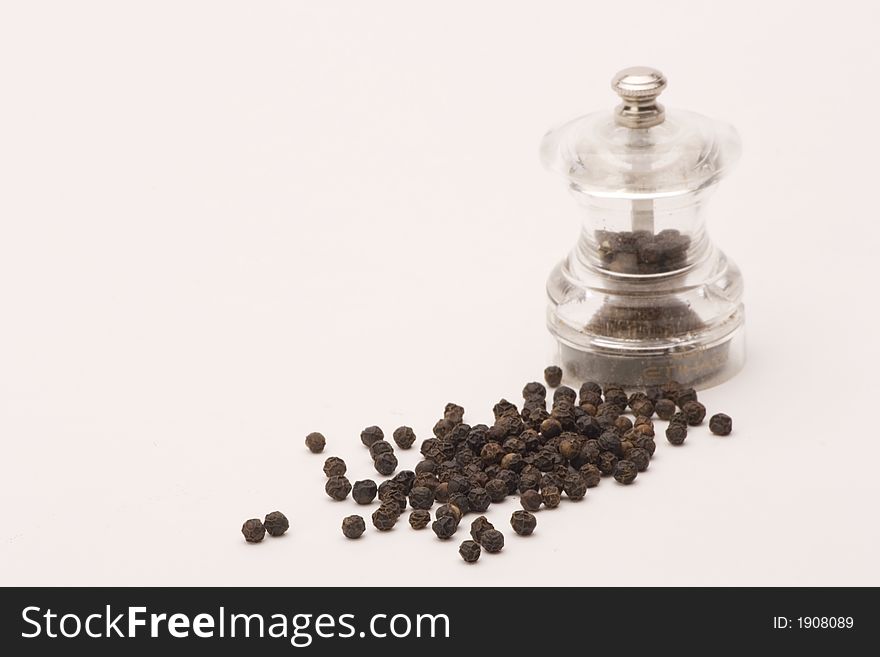 Black peppercorns shot against a plain background