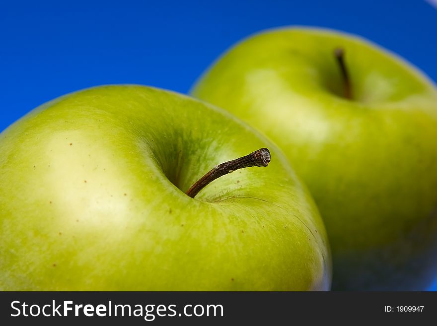 Appetizing apples of green color on a blue background