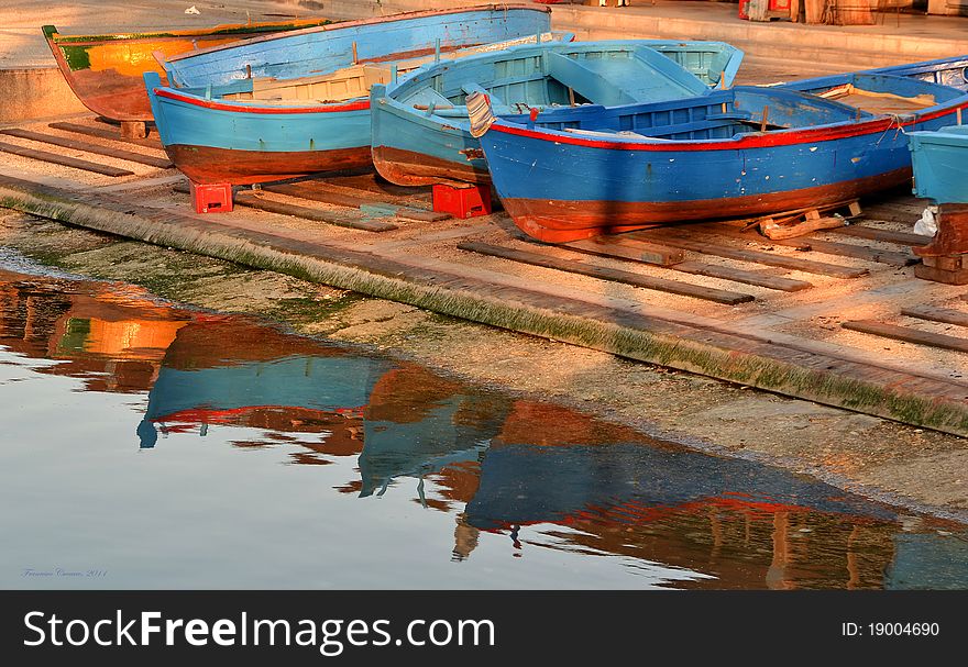 Colored boats on wharf by the sea. Colored boats on wharf by the sea