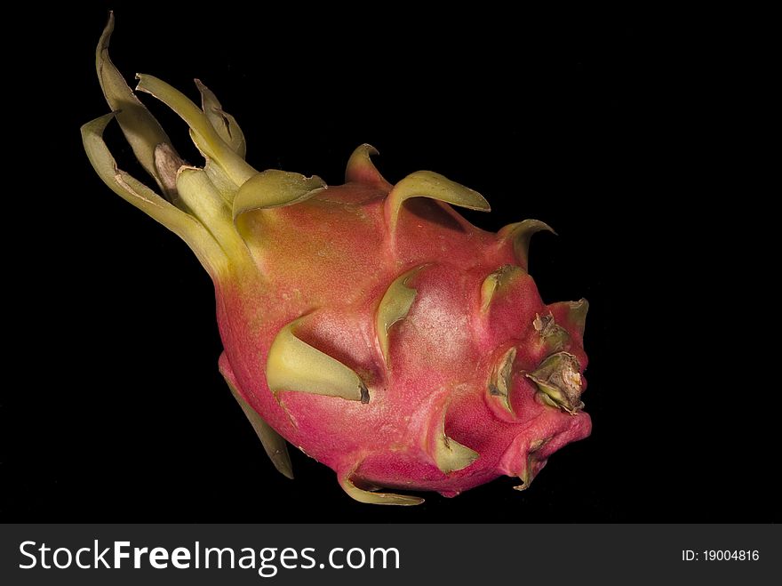 This is a dragon fruit over a black background.