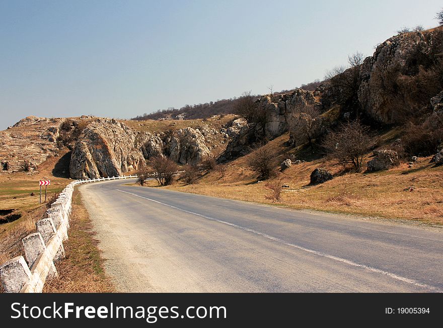 Empty country side road passing through the stony hills. Empty country side road passing through the stony hills.