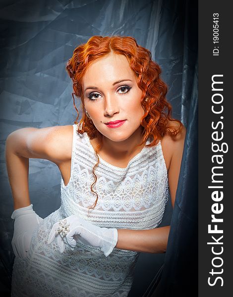 Portrait of girl with beautiful red curly hair wearing white short dress and gloves. Portrait of girl with beautiful red curly hair wearing white short dress and gloves