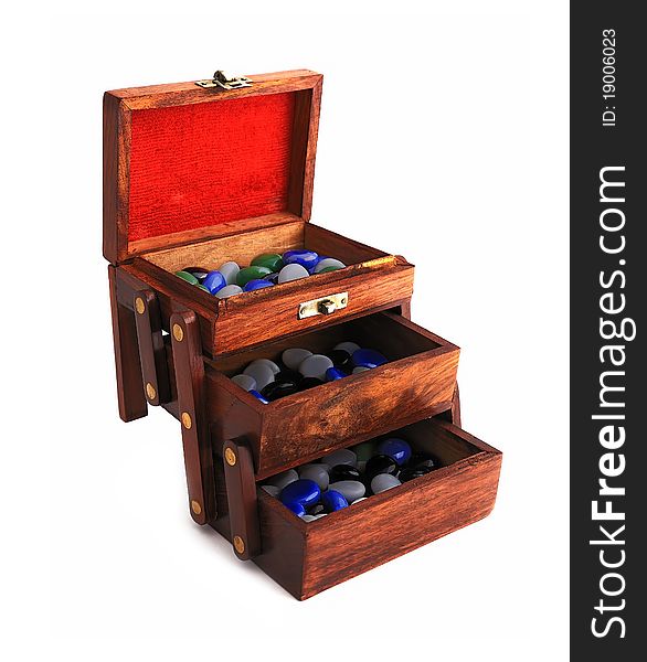 Wooden box with colored stones on a white background. Wooden box with colored stones on a white background