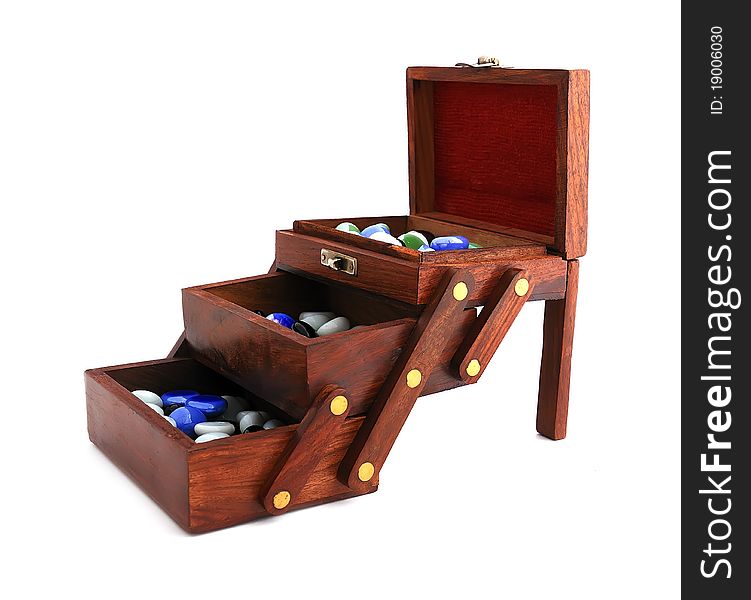 Wooden box with colored stones on a white background. Wooden box with colored stones on a white background