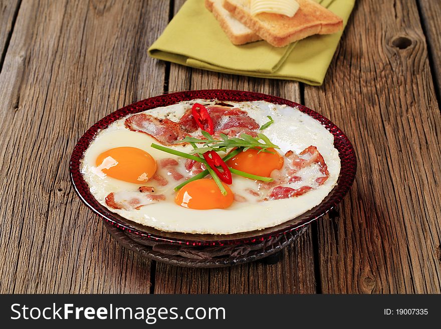 Fried eggs with slices of bacon - sunny side up. Fried eggs with slices of bacon - sunny side up