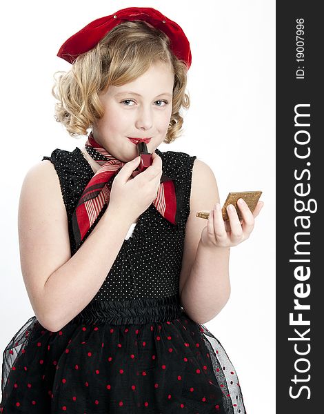 Cute little girl wearing dress putting on red lipstick. Cute little girl wearing dress putting on red lipstick