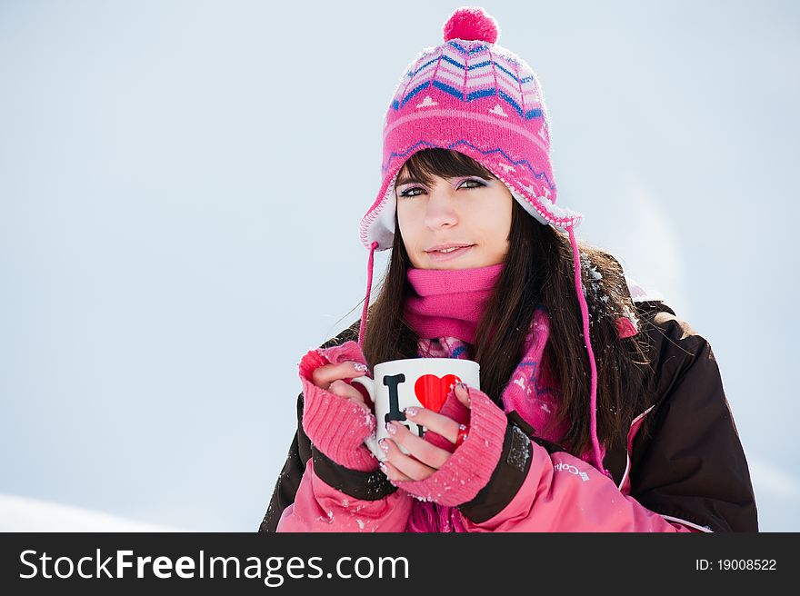 Attractive winter woman with the cup of tea on snow background. Attractive winter woman with the cup of tea on snow background