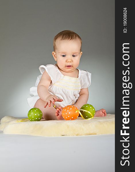 Young babay girl sitting and playing with easter egg. Very cute baby. Young babay girl sitting and playing with easter egg. Very cute baby.