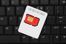 SIM Card On Computer Keyboard Stock Photo SIM Card On Computer Keyboard Stock Photo