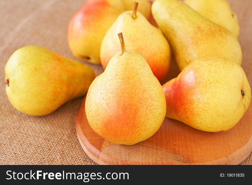 Bunch of ripe yellow pears on mesh background