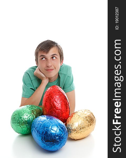 Boy with very large easter eggs is looking sideways. Thinking pondering wishing. Space for text. White background. Boy with very large easter eggs is looking sideways. Thinking pondering wishing. Space for text. White background.