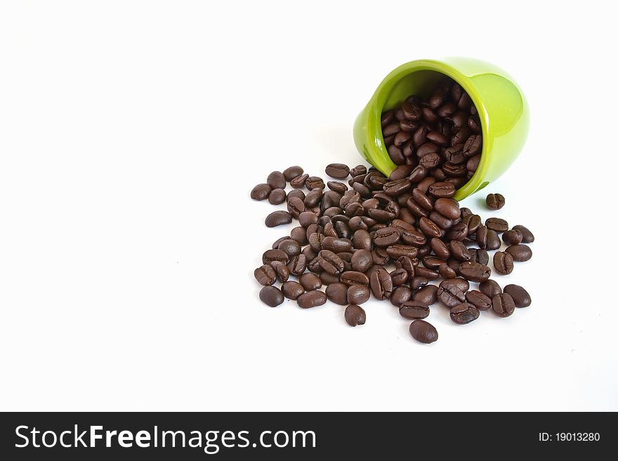 Coffee beans in green cup on white background