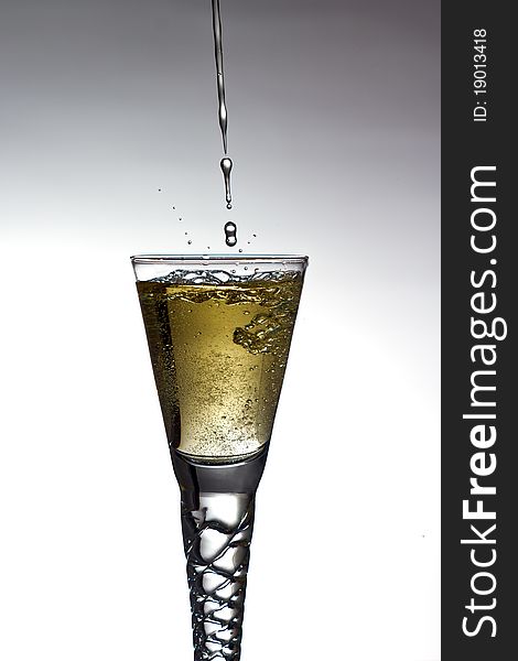 Champagne pouring into glass on gratuated background