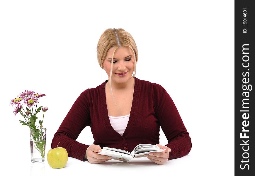 Pretty female with green apple reading book