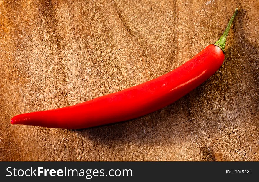 Red Hot Chili Pepper on the old wooden background