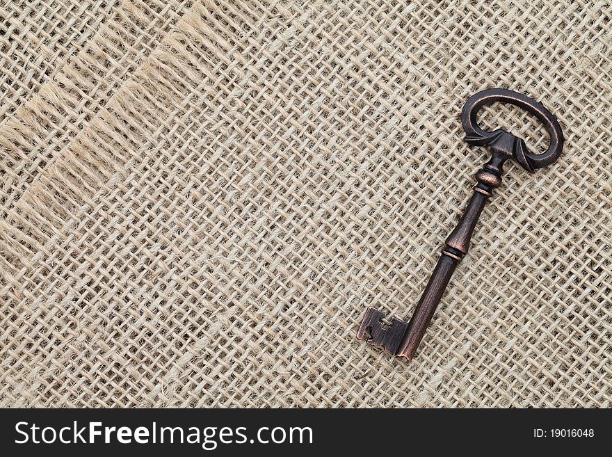 Old key on burlap background