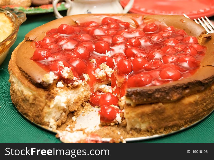 Cherry topped cheese cake with a slice removed. Cherry topped cheese cake with a slice removed.