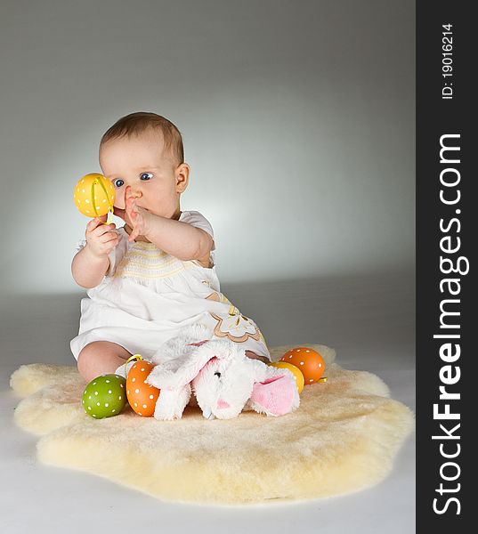 Young babay girl sitting and playing with easter egg. Very cute baby. Young babay girl sitting and playing with easter egg. Very cute baby.