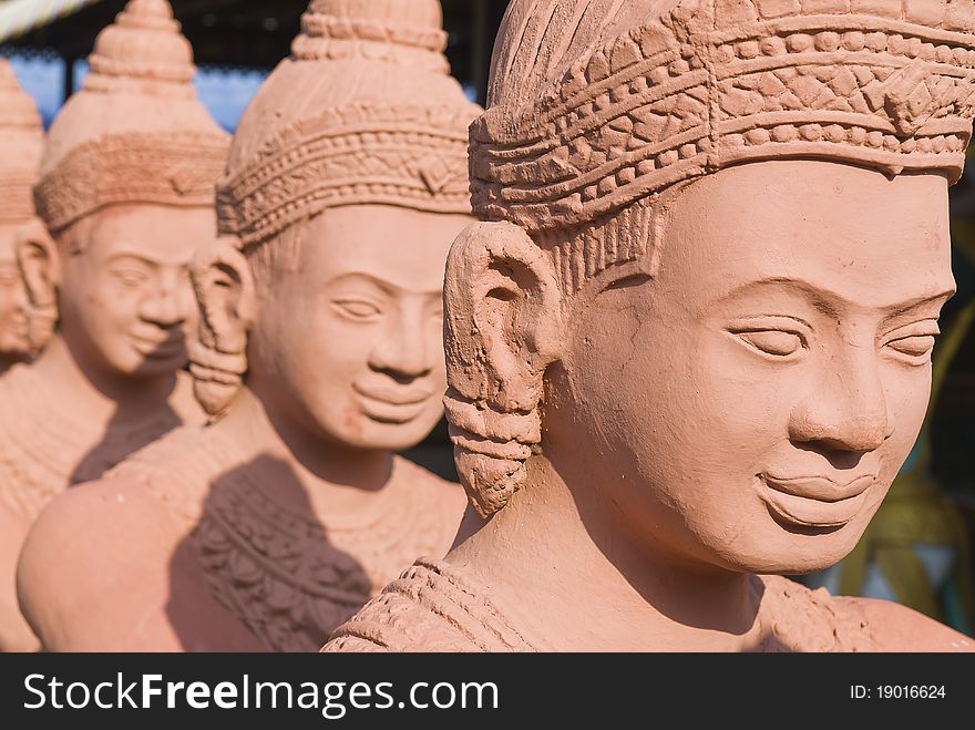 Long row of traditional statues guarding the entrance to a Buddhist temple