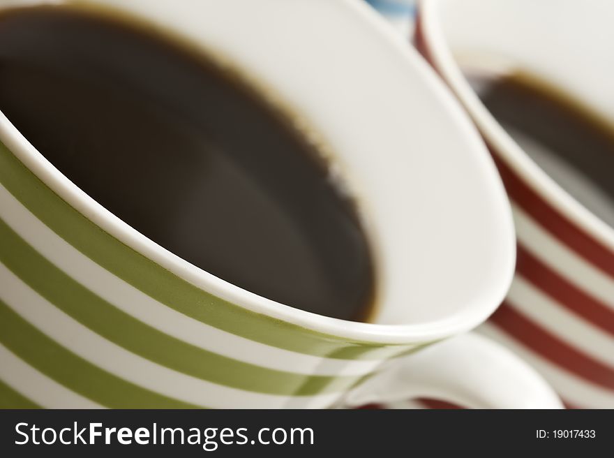 Close ups of colorful mugs of black coffee. Close ups of colorful mugs of black coffee