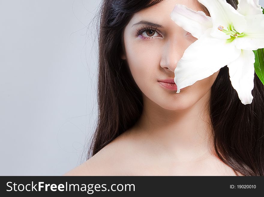 Beautiful young woman with fresh clean skin and white flower. Beautiful young woman with fresh clean skin and white flower